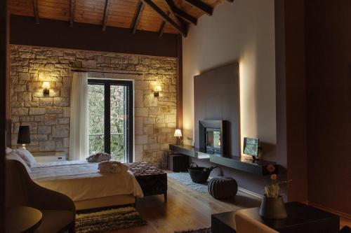 a bedroom with a bed and a stone wall at Levidi Suites in Levidi