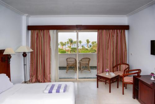 a hotel room with a bed and a balcony at Brayka Bay Reef Resort in Abu Dabab