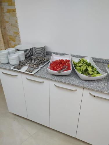 a kitchen counter with bowls of vegetables and plates at Asmir Suites Hotel in Nevsehir