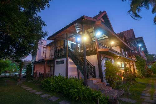 a house with lights on the side of it at Kongmany Colonial House in Muang Không