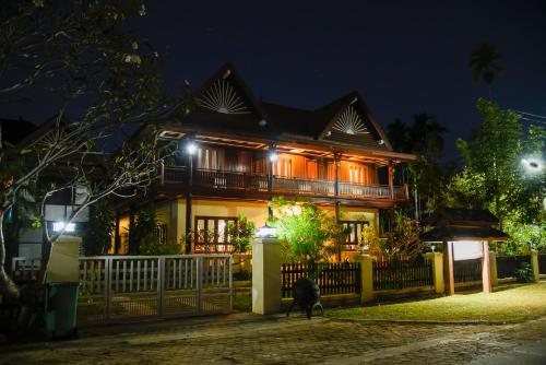 a dog standing in front of a house at night at Kongmany Colonial House in Muang Không