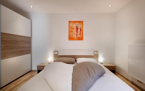 een slaapkamer met 2 bedden en een schilderij aan de muur bij Apartment Viktoria in Castelbello