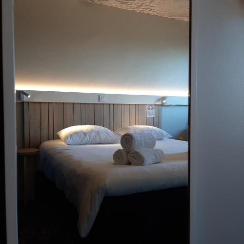 a bedroom with a bed with towels on it at ibis Rennes Cesson in Cesson-Sévigné