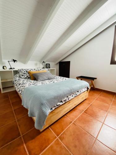 a bed in a room with a white ceiling at LA CRUZ DE LA ATALAYA in Benamahoma
