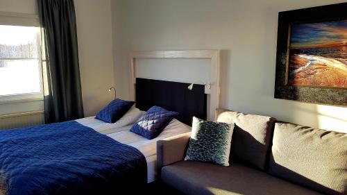 a bedroom with a bed and a couch and a painting at Ulvsby Herrgård in Sunne