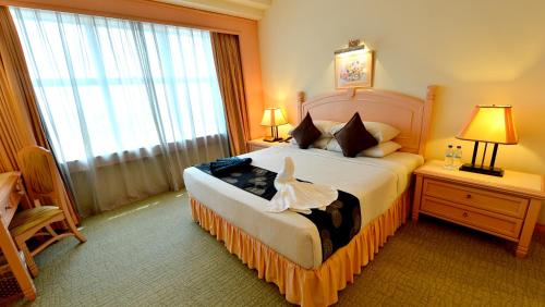 a bedroom with a bed and a large window at Emerald Puteri Hotel in Sungai Petani