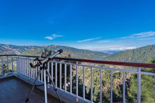 a telescope on a balcony looking at the mountains at juSTa Mukteshwar Retreat & Spa in Mukteswar