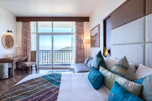a bedroom with a large bed and a large window at juSTa Mukteshwar Retreat & Spa in Mukteswar