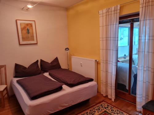 1 dormitorio con cama y ventana en Ferienwohnung Salburg,Tröpolach, en Tröpolach