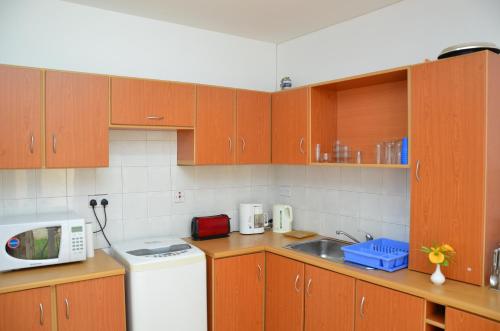 a kitchen with wooden cabinets and a white refrigerator at Residences Beach Apartment in Flic-en-Flac