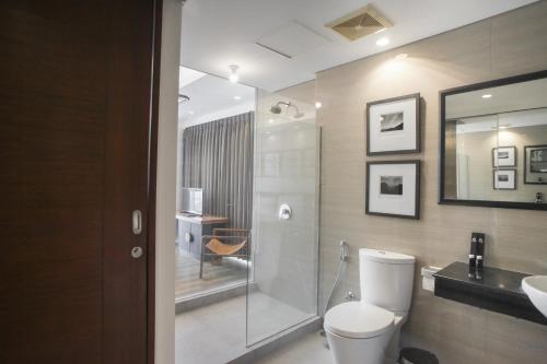 a bathroom with a shower and a toilet and a sink at Premium 2BR Apartment near Marvell City Mall at The Linden By Travelio in Surabaya