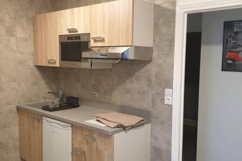 une cuisine avec un évier et une cuisinière dans l'établissement Appartement 50 m2, Calme, Marche à pied, Proche mer, à Guidel