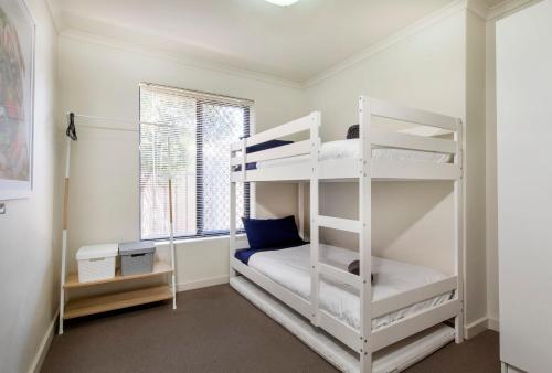 a bedroom with two bunk beds and a window at Stylish 3 bed, 300m to the beach Wifi, Parking, Glenelg South in Glenelg