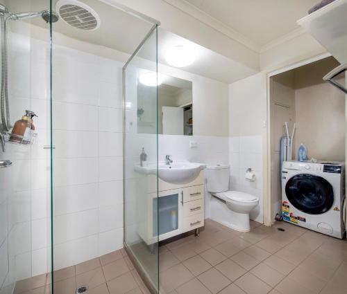 a bathroom with a sink toilet and a washing machine at Stylish 3 bed, 300m to the beach Wifi, Parking, Glenelg South in Glenelg