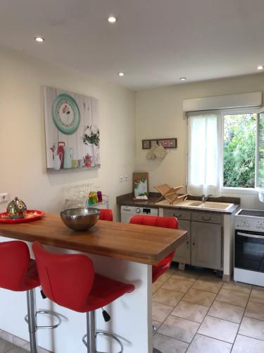 une cuisine avec une table en bois et des chaises rouges dans l'établissement Appartement PALAZZI 2, à LʼÎle-Rousse