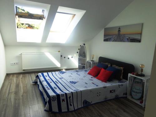 a bedroom with a bed with blue and red pillows at Frangipani in Siófok