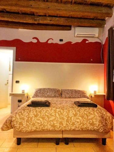 a bedroom with a large bed with a red wall at Terrazza Tassis Charme&Relax in Bergamo