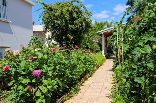 a garden with pink flowers and a pathway at Apartment Garden M&M in Dubrovnik