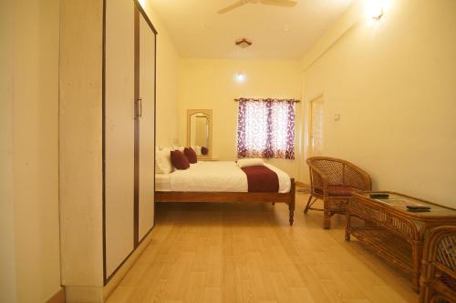 a bedroom with a bed and a window at Cliffhanger Retreat in Yercaud