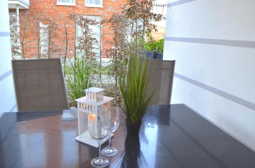 einen Esstisch mit einer Vase mit einer Pflanze in der Unterkunft Appartement Fienchen 1 SZ Terrasse by Unsere Urlaubszeit in Kellenhusen