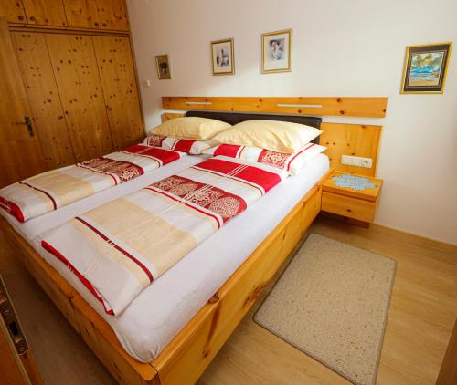 ein Schlafzimmer mit einem großen Bett mit einem Holzrahmen in der Unterkunft Appartement Else in Bad Kleinkirchheim