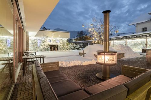 a patio with a couch and a table and snow at Hotel Restaurant Langgenhof in Brunico