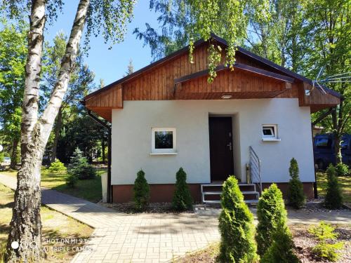 a small white house with a wooden roof at Camp Marina in Sulęcin