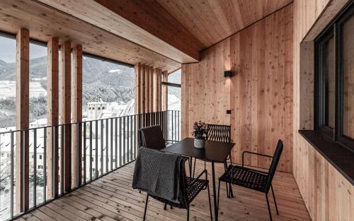 a room with a table and chairs on a balcony at Ölackererhof in Bressanone