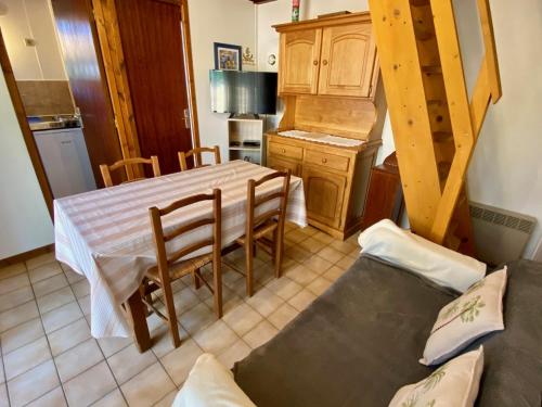 un salon avec une table et une cuisine dans l'établissement Cute chalet very central & close to the beach, à Lacanau