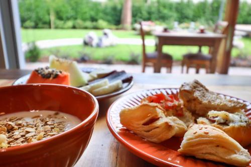 een tafel met een bord eten en een kom soep bij Pousada Serra Paradiso in Gramado