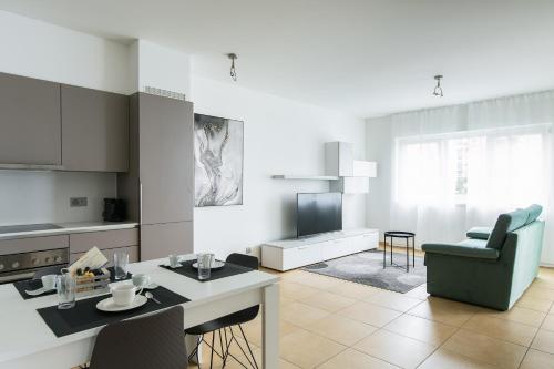 a kitchen and living room with a table and chairs at Prestige Apartments by Quokka 360 - spacious flats with terraces in Lugano