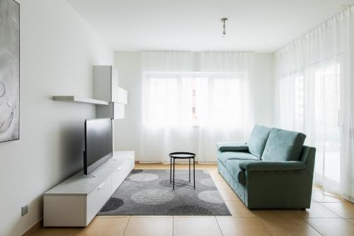 a living room with a blue couch and a tv at Prestige Apartments by Quokka 360 - spacious flats with terraces in Lugano