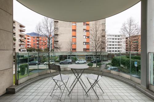 a table and chairs on a balcony with a view of a city at Prestige Apartments by Quokka 360 - spacious flats with terraces in Lugano