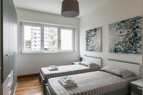 two beds in a room with two windows at Prestige Apartments by Quokka 360 - spacious flats with terraces in Lugano