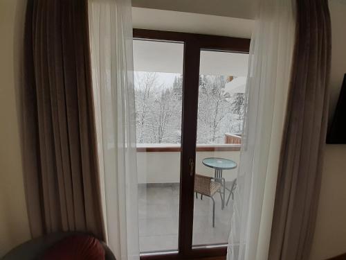 シナイアにあるNobila Sinaiaのバルコニーを望むガラスドア付きの客室です。