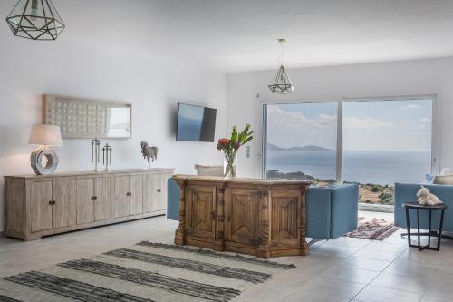 a living room with a large sliding glass door with the ocean at Villa Apollonia in Fiskardho