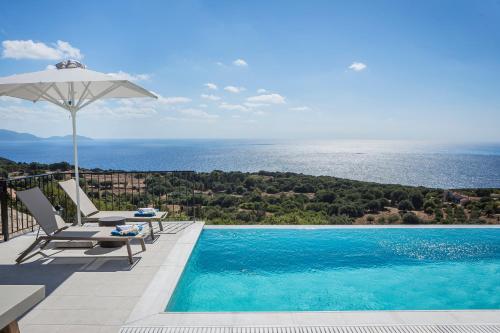 a swimming pool with two chairs and an umbrella at Villa Apollonia in Fiskardho