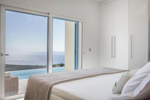 a bedroom with a large window with a view of the ocean at Villa Apollonia in Fiskardho
