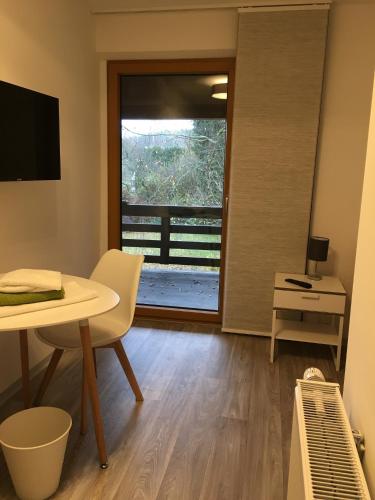 a living room with a table and a window at Pension Jägerschenke in Luhe-Wildenau