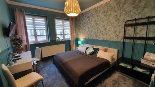 a bedroom with a bed and a desk and a chair at Pension Da Gigi in Oschersleben