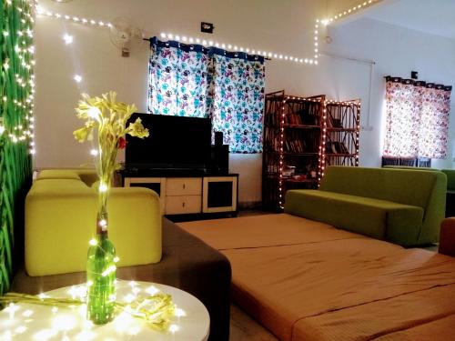a living room with a vase of flowers on a table at Hostel Lifespace- Tailor made for working professionals- Luxurious Twin Bungalow with CoWork- only 3 and 4 share Rooms in Pune