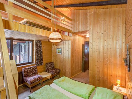 ガルゲレンにあるFerienwohnung mit Sauna in Gargellen - A 064.006 - 8のベッド1台、椅子2脚、窓が備わる客室です。