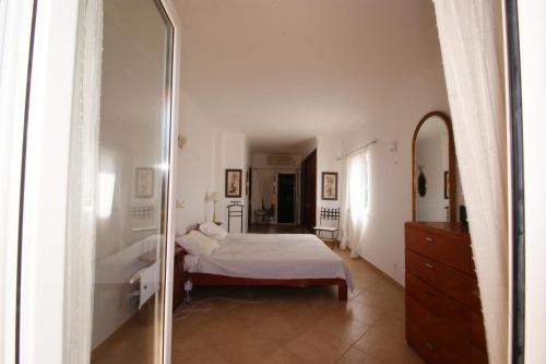a bedroom with a bed and a mirror at Vivenda Luz e Lúdica in Altura