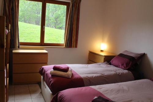 une chambre avec deux lits et une fenêtre dans l'établissement 7-28 day stay for best rates- Chalet Les Carroz, aux Carroz d'Arâches