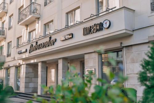a building with a clock on the front of it at Ambassador Hotel in Bishkek