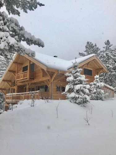 une cabane en rondins avec de la neige sur le toit dans l'établissement Chalet 