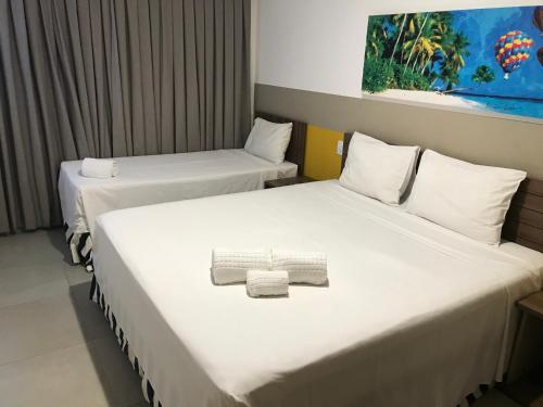 duas camas num quarto de hotel com toalhas em Flat em Olímpia em frente ao Park em Olímpia