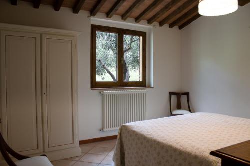 1 dormitorio con cama y ventana en Agriturismo L' Agresto en Casole dʼElsa