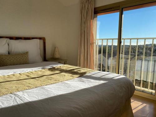 a bedroom with a bed and a large window at Avocado Hôtel in Saint-Jeannet
