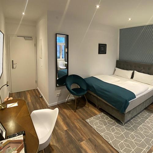 a bedroom with a bed and a desk and a chair at Nurban Apartments Oldtown in Nürnberg